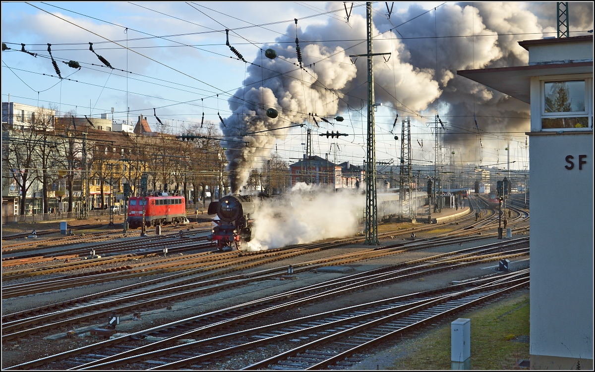 01 1066 bei der Abfahrt in Singen (Htw) Richtung Gotthard. Im Hintergrund steht mit 115 261 ein weiteres einstiges Paradepferd Deutscher Bahnen. März 2015.