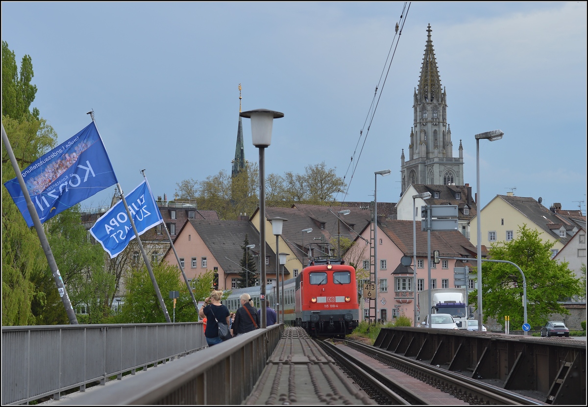 Auch im April 2014 kein Ende der 110 mit den ICs Zürich-Stuttgart. Daher kam 115 198-4 auch wieder nach Konstanz. Hier auf der Rheinbrücke mit der Leerfahrt von IC 2005 zurück nach Singen. Links hängen die Fahnen zum Konzilsjubiläum statt der sonst üblichen Nationalflaggen. April 2014.