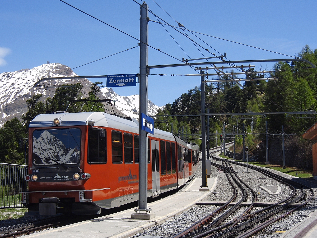 Berge nicht nur im Hintergrund sondern auch als Spiegelbild in der Frontscheibe des Triebwagens. Der nach Zermatt fahrende Triebwagen 3083 der Gornergratbahn bei der Einfahrt in die Station Riffelalp (16.05.2013).