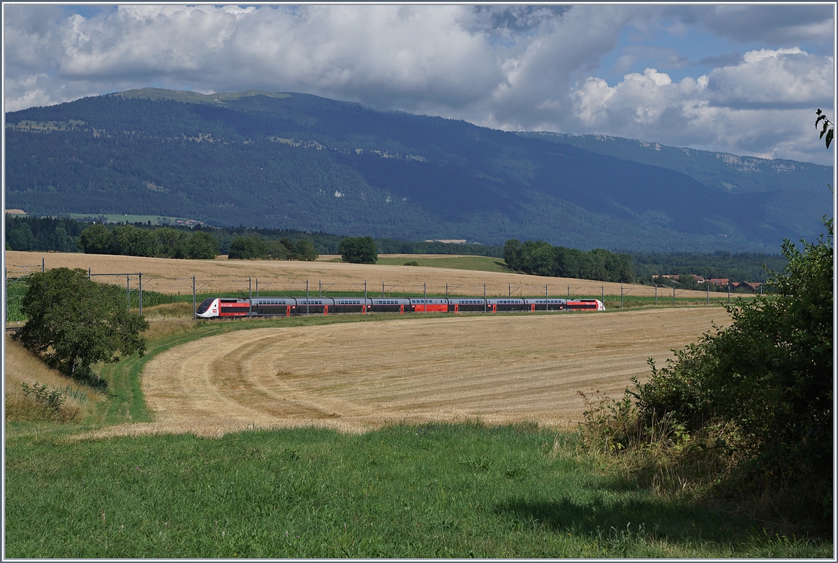 Der TGV Lyria 9261 von Paris Gare de Lyon nach Lausanne oberhalb von Arnex auf der Fahrt durch die hügligen Jurasüdfuss Landschaft. 

25. Juli 2020