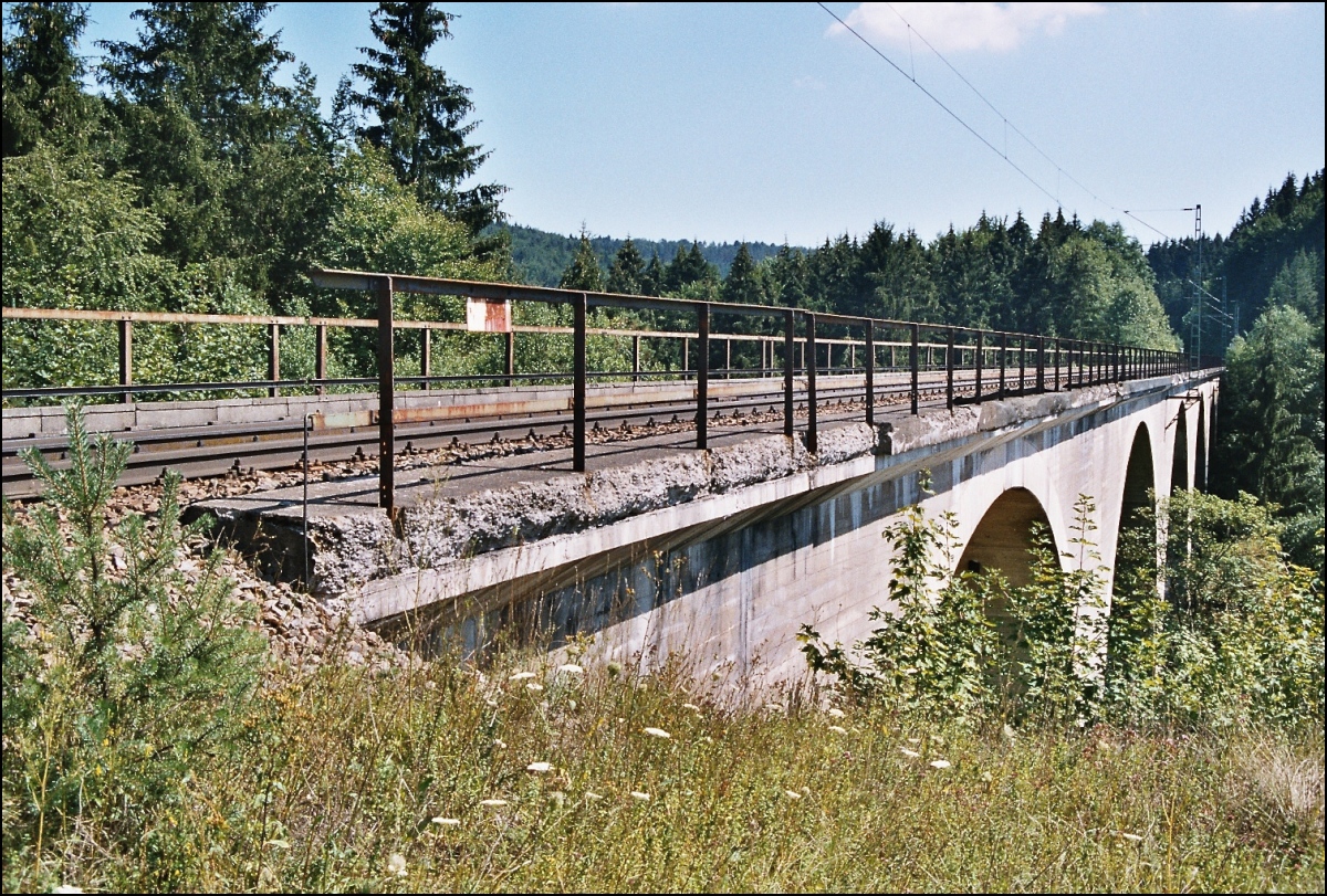 Die jahrzehntelange Vernachlässigung der Gäubahn ist hier versinnbildlicht. Der Viadukt der Hattinger Kurve oberhalb der Donauversickerung zeigt sich im August 2003 noch in morbidem Charme.