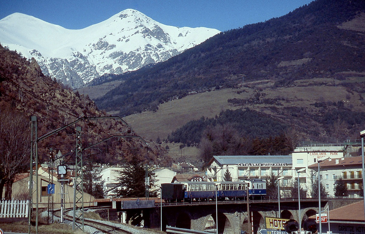 Die meterspurige Cremellara de Nuria befindet sich in den spanischen Pyrenen und wird von der FGC (Ferrocarrils de la Generalitat de Catalunya) betrieben. Sie fhrt von Ribes de Freser (905 m) in das 1.964 m hoch gelegene Tal von Nuria. Zur Erffnung im Jahre 1931 beschaffte die Bahn vier Zahnradlokomotiven bei SLM/BBC. Hier schiebt die 1930 gebaute E4  Ramon Albo  (SLM 3371/BBC 2972) im Februar 1996 einen Zug in den Talbahnhof.