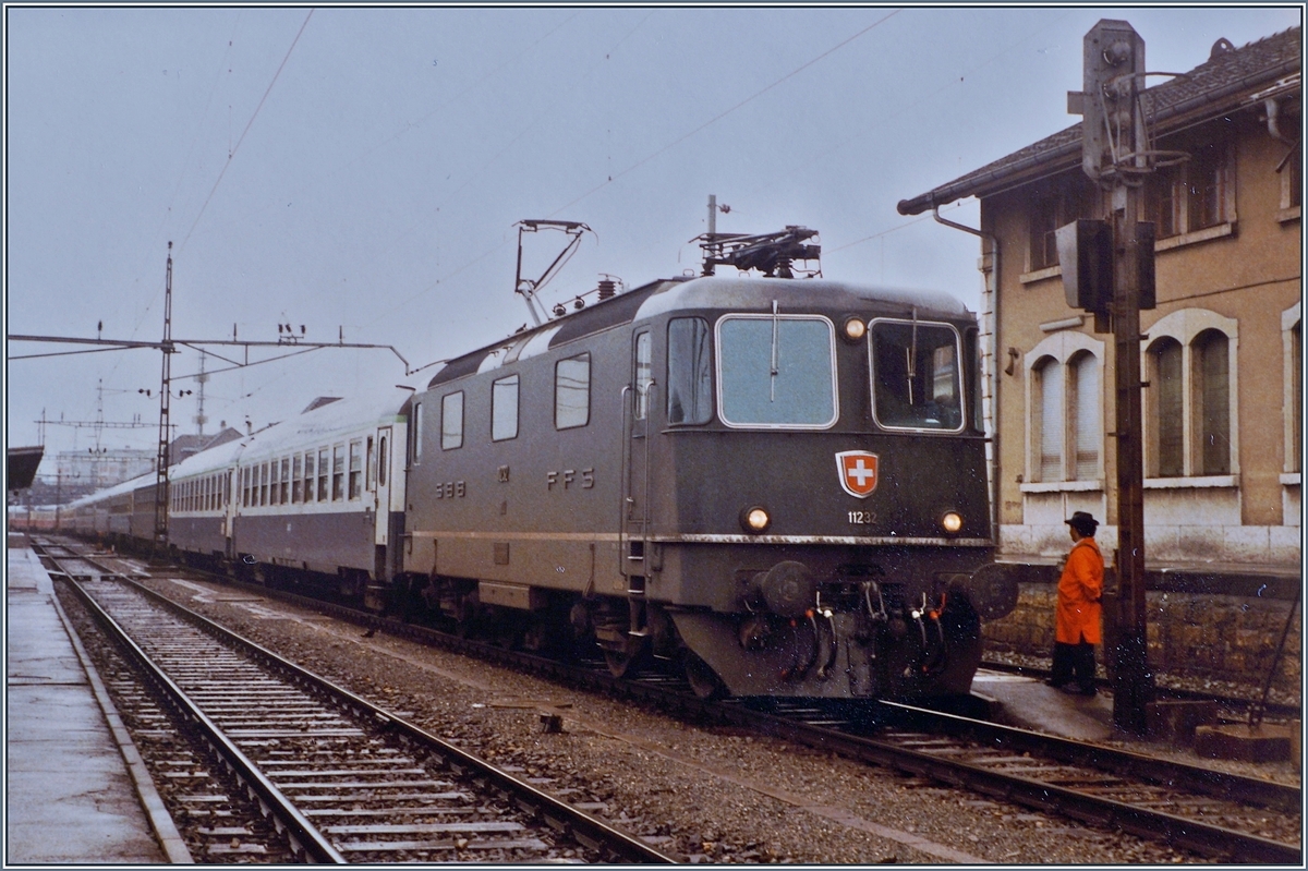 Die SBB Re 4/4 II 11232 wartet nach der Übernahme des  Hispania - Express nach dem Fahrtrichtungswechsel in Delémont auf die Weiterfahrt nach Basel. Der Zug besteht aus zwei Teilen: dem IC/EC Hispania von Genève nach Hamburg und dem Nachtzug Port-Bou bzw. Cerbère - Basel (-Hamburg).

16. Sept. 1984 
