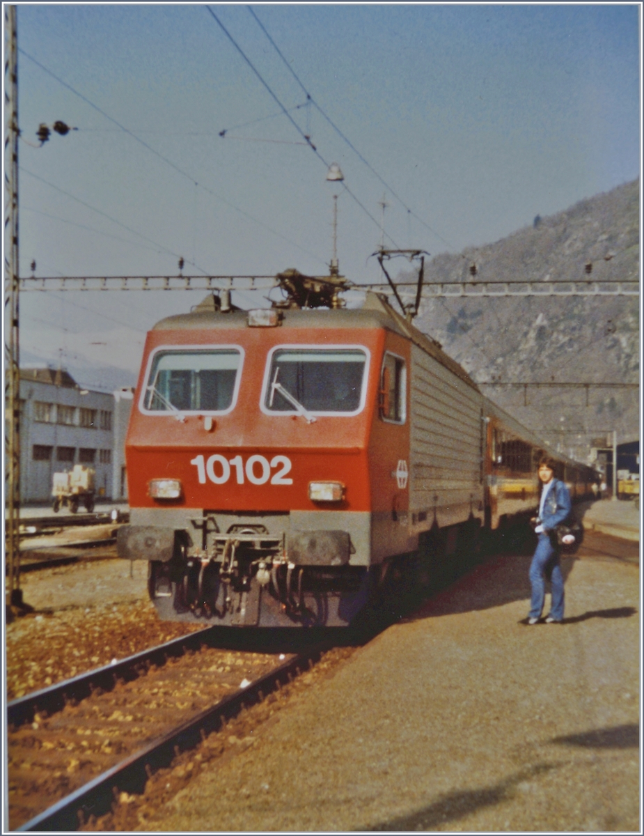 Die SBB Re 4/4 IV 10102 wartet in Brig mit ihrem Schnellzug 321 Genve/(Bern)- Brig - Milano - Venezia auf die Abfahrt.
19. April 1984