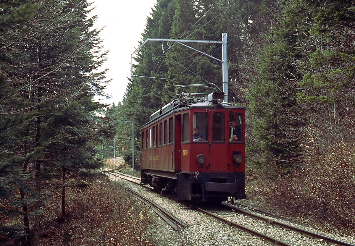 Ein ABDe 4/4 der NStCM ist im Mai 1980 zwischen St. Cergue und Arzier unterwegs. Zur Schonung der nicht nachgespannten Fahrleitung verkehrten die Triebwagen abwrts mit abgesenktem Stormabnehmer.