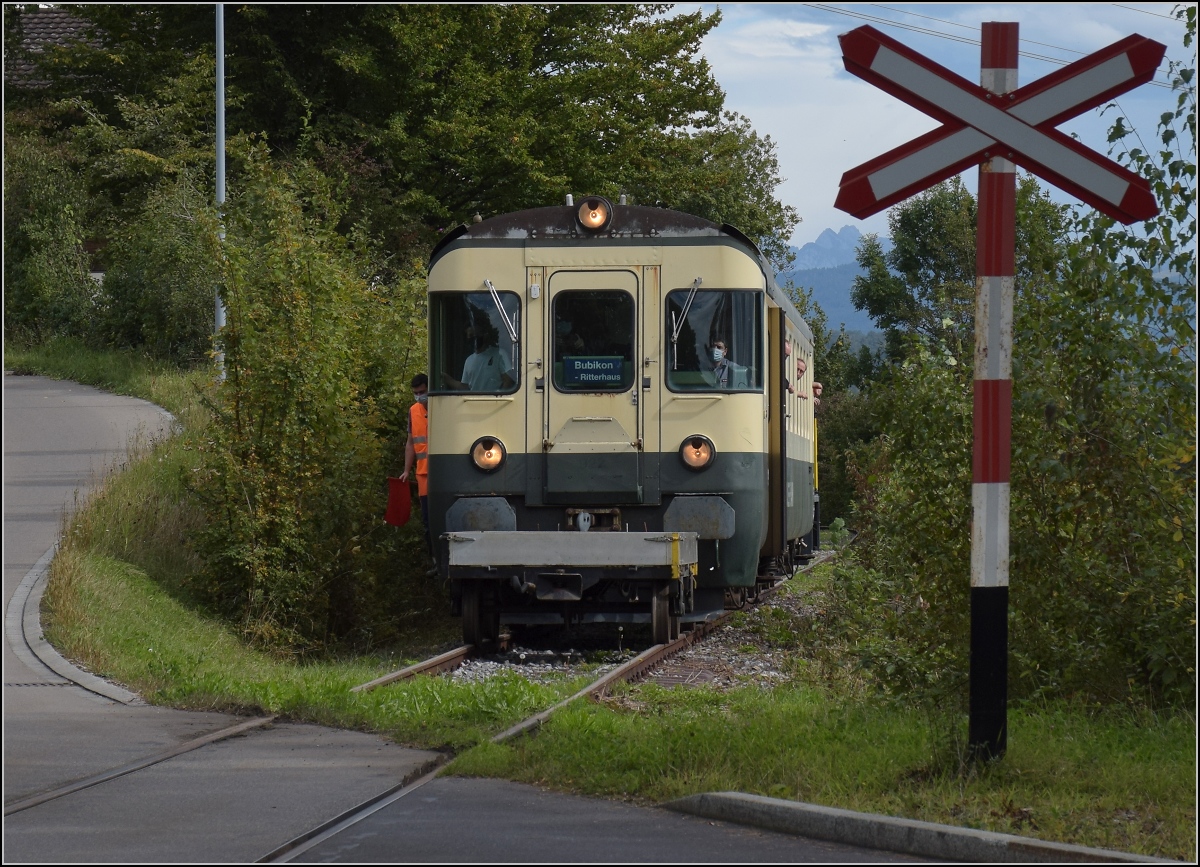 Fahrtag Wolfhuuser Bahn.

Passage des Bahnübergangs am Ortsende Wolfhausen, vorne der ABt der IG Stammgleis Wolfhausen–Bubikon. Oktober 2021.