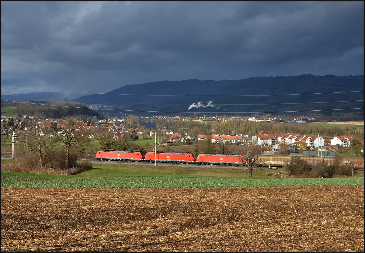 Für zwei Loks war die Lücke passend, aber wer rechnet schon mit einer Dreifachtraktion auf der Bötzbergstrecke. 3 DB 185er mit einem langen Güterzug bei Mumpf auf dem Weg nach Basel. März 2017.