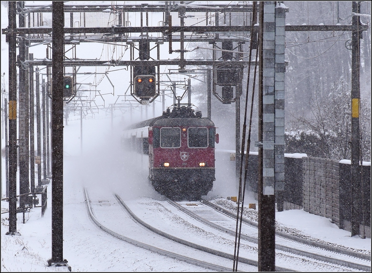 Heftiger Schneefall vor genau zwei Jahren in Tecknau. Re 4/4 II 11197 kämpft sich mit einem IR den Weg zum Hauen
steinbasistunnel frei. Januar 2017.