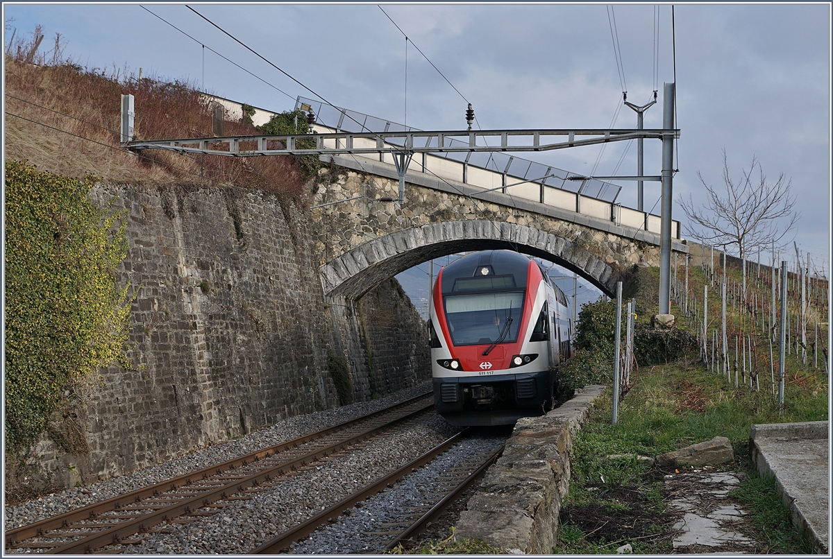In Cully steht eine der wenigen  alten  Brücken über die Simplon Linie, welche auch Doppelstockzügen genügend Platz bietet und nicht ersetzt werden musste. Das Bild zeigt den SBB RABe 511 117 als RE 3122 von Vevey nach Genève.
30. Jan. 2018
