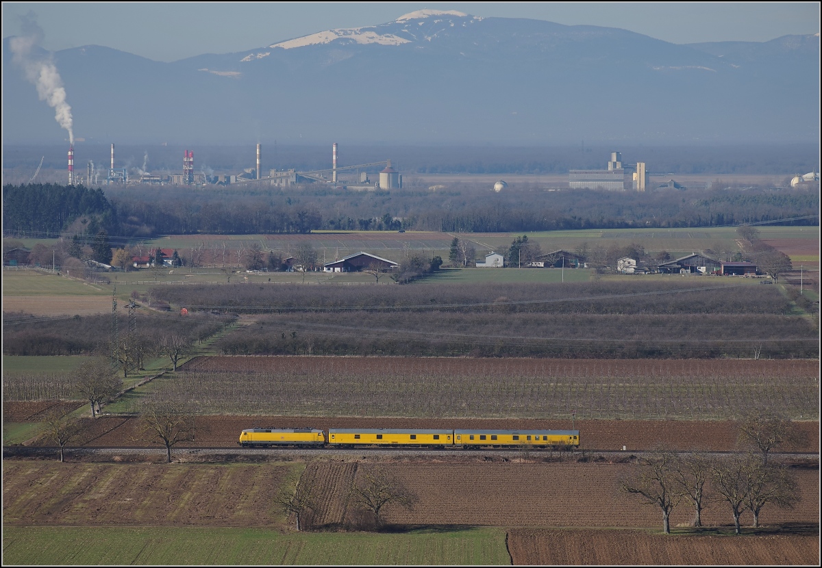 Messzug Nbz 94321 mit 120 160-7 Hockenheim-Basel. Im Hintergrund ist das große Belchen zu sehen, der höchste Berg der Vogesen. Auggen, Februar 2019.
