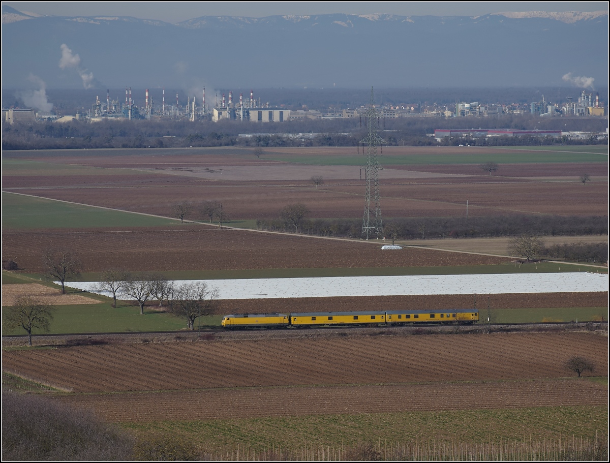 Messzug Nbz 94321 mit 120 160-7 Hockenheim-Basel. Ein Riegel an Industrie markiert die Grenze zu Frankreich. Auggen, Februar 2019.