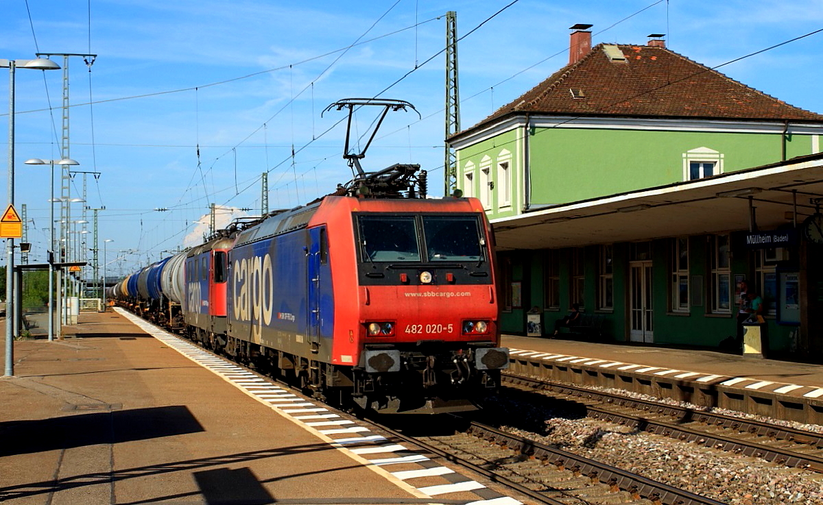 Mit einer 421 im Schlepp befördert 482 020-5 der SBB Cargo einen Tankzug in Richung Süden (Müllheim/Baden 07.08.2015). Manche Fahrgäste werden sich vielleicht ärgern, aber der Eisenbahnfotograf freut sich, dass es hier noch keine Hochbahnsteige gibt.