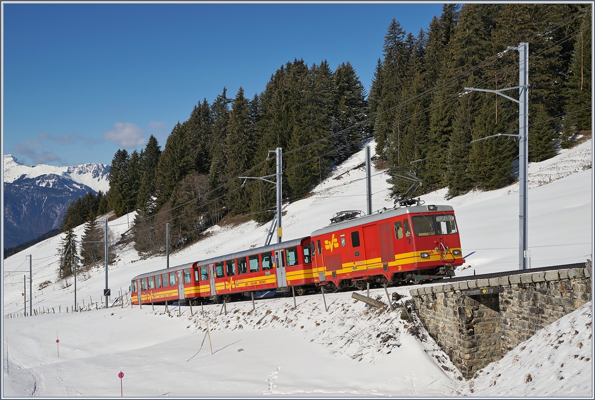 Mit ihrem farblich passenden Zug fährt die BVB TPC HGe 4/4 31 bei Col du Soud Talwärts nach Villars sur Ollon.

5. März 2019