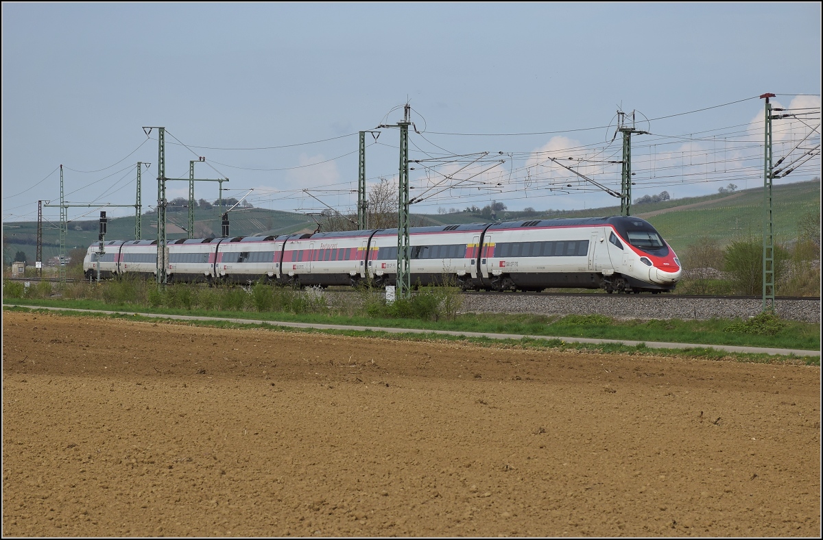 RABe 503 019-6 auf seiner Reise nach von Mailand nach Frankfurt. Im Hintergrund die Auggener Weinberge. Schliengen, April 2018.