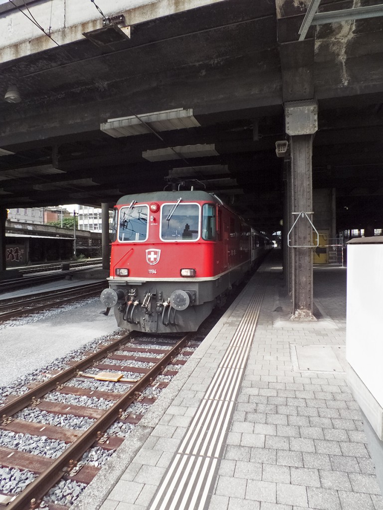 Re 4/4II 11194 verlässt am 04.08.14 den teils überbauten und im hinteren Bereich mit einer großzügigen Bahnhofshalle ausgestatteten Bahnhof Basel SBB und macht sich mit einem IC auf den Weg nach Zürich.