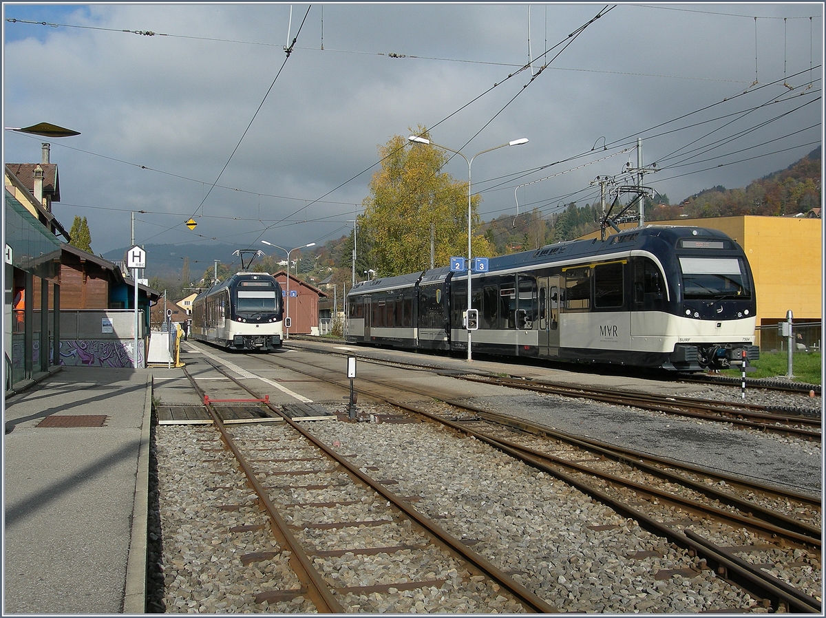  Regio Express  nach Prélaz und der Regionalzug 1428 nach Vevey warten in Blonay auf Abfahrt. 
15. Nov. 2016