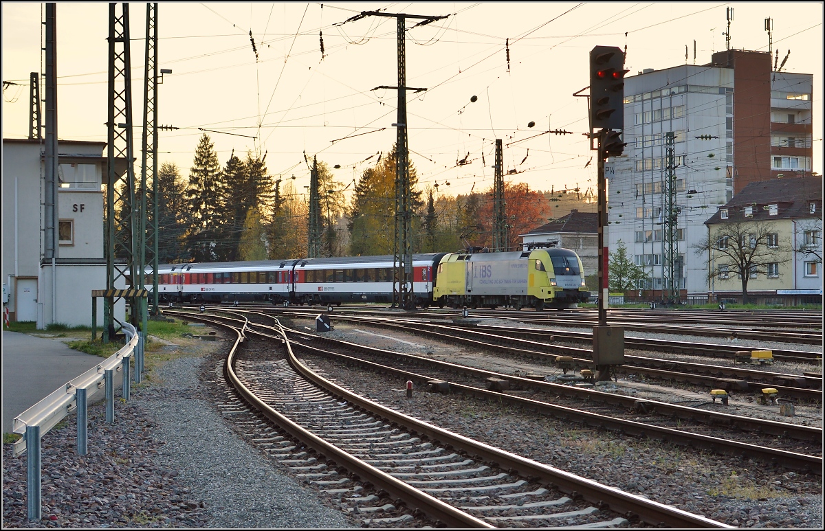 Stierkampf auf der Gäubahn. Zur Abwechslung verfolgt 182 596-7 die rote 146 der Schwarzwaldbahn und erreicht mit IC 283 den Bahnhof Singen. April 2015.