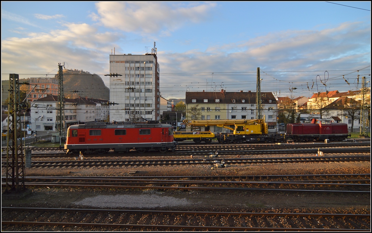 Unter dem Hohentwiel setzt sich Re 4/4 II 11114 vor IC 187 nach Zrich. Im Hintergrund 212 133-3 mit einem Schienenkran. November 2013.