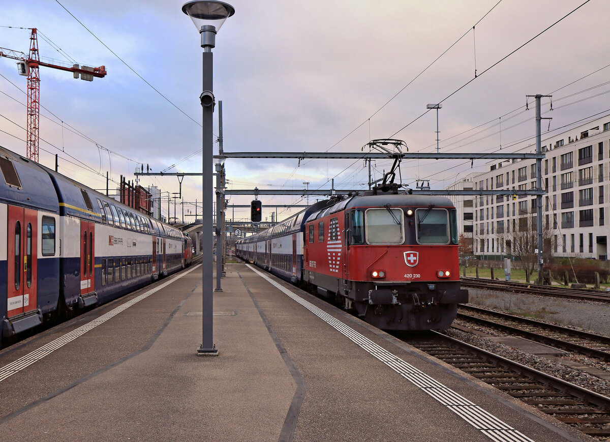 Während links eine S-Bahn S19 auf Abfahrt Richtung Effretikon - Winterthur wartet, fährt eine andere S19 mit einer Re420 je hinten und vorn in Wallisellen ein. Lok 420 230. 6.Februar 2023 