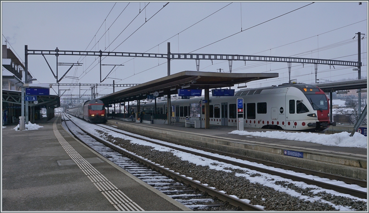 Während in Romont ein TPF RABe 527 auf die Abfahrt nach Ins wartet nähert sich eine SBB Re 460 mit ihrem IR 15 nach Luzern. 

22. Dez 2021 