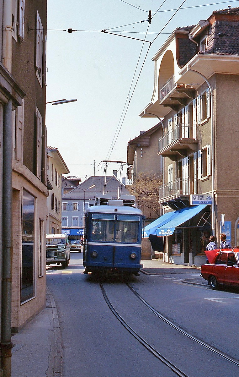 Ziemlich eng geht es auf der Rue Centrale in Bex zu: Nachschuss auf den in Richtung Bahnhof fahrenden Be 2/3 15 der BVB im Mai 1980, vorschriftsmäßig räumt der Jeep im Hintergrund den Platz für den Triebwagen