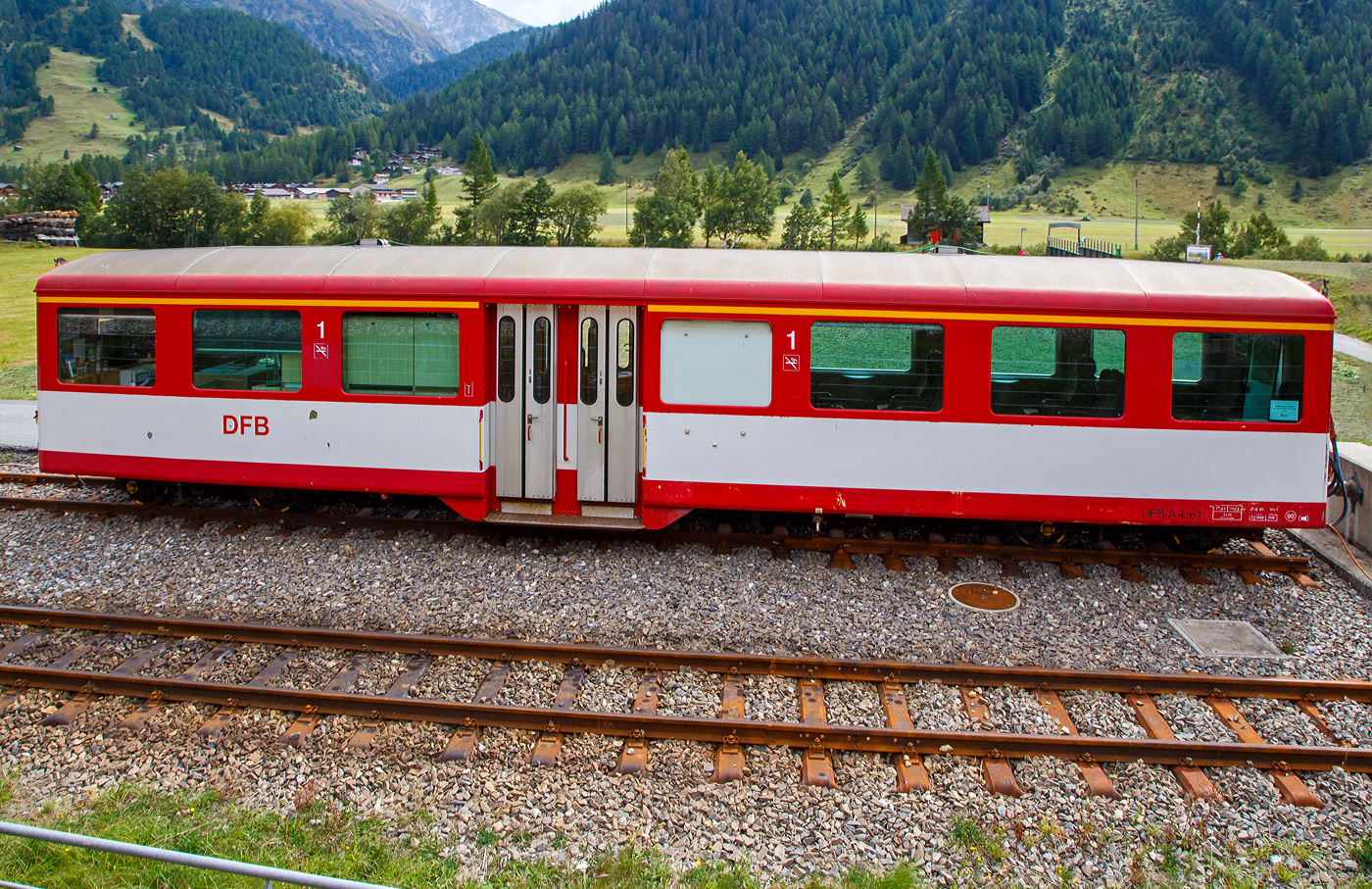 Der vierachsige Personenwagen A 4161 der DFB Dampfbahn Furka-Bergstrecke AG, ex MGB A 2061, ex BVZ A 2061, ein Mitteleinstiegswagen der 1. Klasse noch in MGB Lackierung, ist am 07 September 2021 in Oberwald (Wallis) abgestellt, aufgenommen aus einem fahrenden MGB-Zug heraus. Aktuell ist der Wagen frisch lackiert als DFB Infowagen A 4161 im Bahnhof Oberwald abgestellt (als Provisorium Oberwald, trägt er denVermerk darf den Bhf. Oberwald nicht Verlassen). 

Der Wagen wurde 1961 von SIG (Schweizerische Industrie-Gesellschaft) in Neuhausen am Rheinfall gebaut und an die damalige BVZ (Brig-Visp-Zermatt-Bahn / BVZ Zermatt-Bahn) als A 2061 geliefert. Nach dem Zusammenschuss am 01. Januar 2003 der BVZ mit der Furka-Oberalp-Bahn (FO) zur Matterhorn-Gotthard-Bahn wurde er zum MGB A 2061, im Jahr 2016 ging er dann an die DFB. 

TECHNISCHE DATEN
Hersteller: SIG
Baujahr: 1961
Spurweite: 1.000 mm (Meterspur)
Anzahl der Achsen 4 (2´2´)
Länge über Puffer : 15.780 mm
Länge des Wagenkastens: 14.900 mm
Breite: 2.656 mm
Höhe: 3.365 mm
Drehzapfenabstand: 11.010 mm
Achsabstand im Drehgestell: 1.800 mm
Laufraddurchmesser: 675 mm
Bremszahnrad: System Abt  (Drehgestell Seite Visp/Talseite)
Eigengewicht:  11,8 t 
Ladegewicht:  3 t
Zul. Höchstgeschwindigkeit: 90 km/h
Anzahl der Fenster (1.400 mm breit): 6 (WC-Seite) bzw. 7
Sitzplätze: 34 und 2 Klappsitze
Stehplätze: 6
Lichte Türbreite: 2 x 610 mm
Toiletten: 1
Heizung: Zugsammelschiene RhB/MGB
Bremsen: automatische Vakuum- und Handbremse
Zulassungen: MGB und RhB