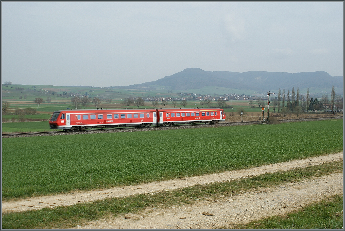Ein DB Dieseltriebzug ist im Klettgau zwischen Neunkirch und Wilchingne Hallau auf dem Weg in Richtung Basel Bad Bf und passiert das Einfahrsignal (der Gegenrichtung) von Neunkich. 

8. April 2021