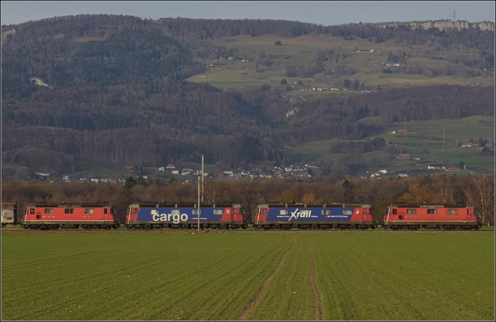 Eine Re 10/10 und eine kalte Re 10/10 waren die Überraschung des Tages. Eine Re 4/4 II und Re 620 088 'Linthal' noch mit Xrail-Aufschrift ziehen den Zug, während Re 620 086 'Hochdorf' mit Cargo-Aufschrift mit einer weiteren Re 4/4 II mitfahren. Deitingen, Dezember 2023.