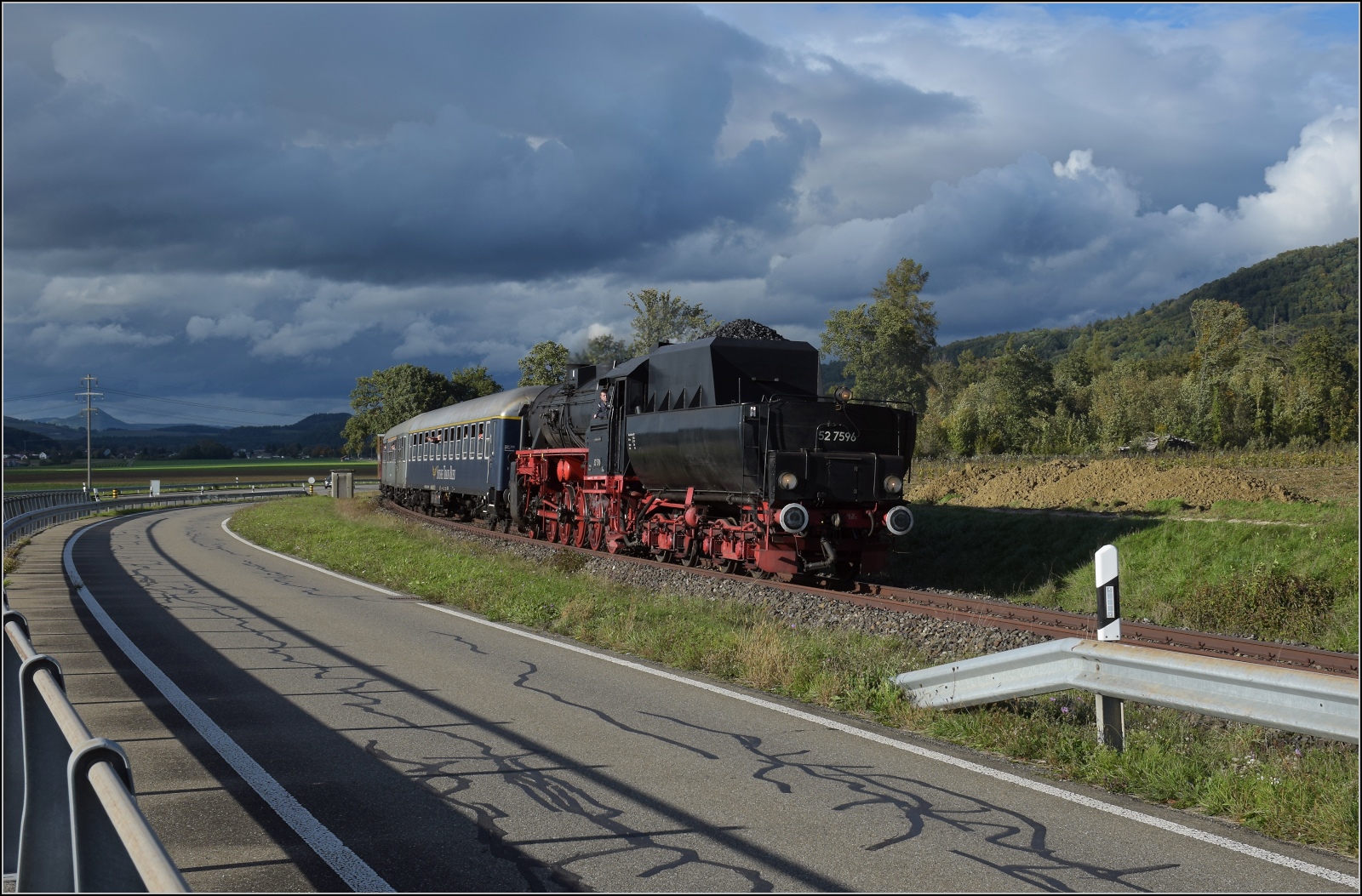 Schienenverkehr am Schienerberg. 

52 7596 mit ihrem EFZ-Sonderzug für die SEHR&RS zwischen Ramsen und Hemishofen. Vom Masten leider etwas verdeckt ist der höchste der Hegauvulkane, der Hohenhewen. Oktober 2022.