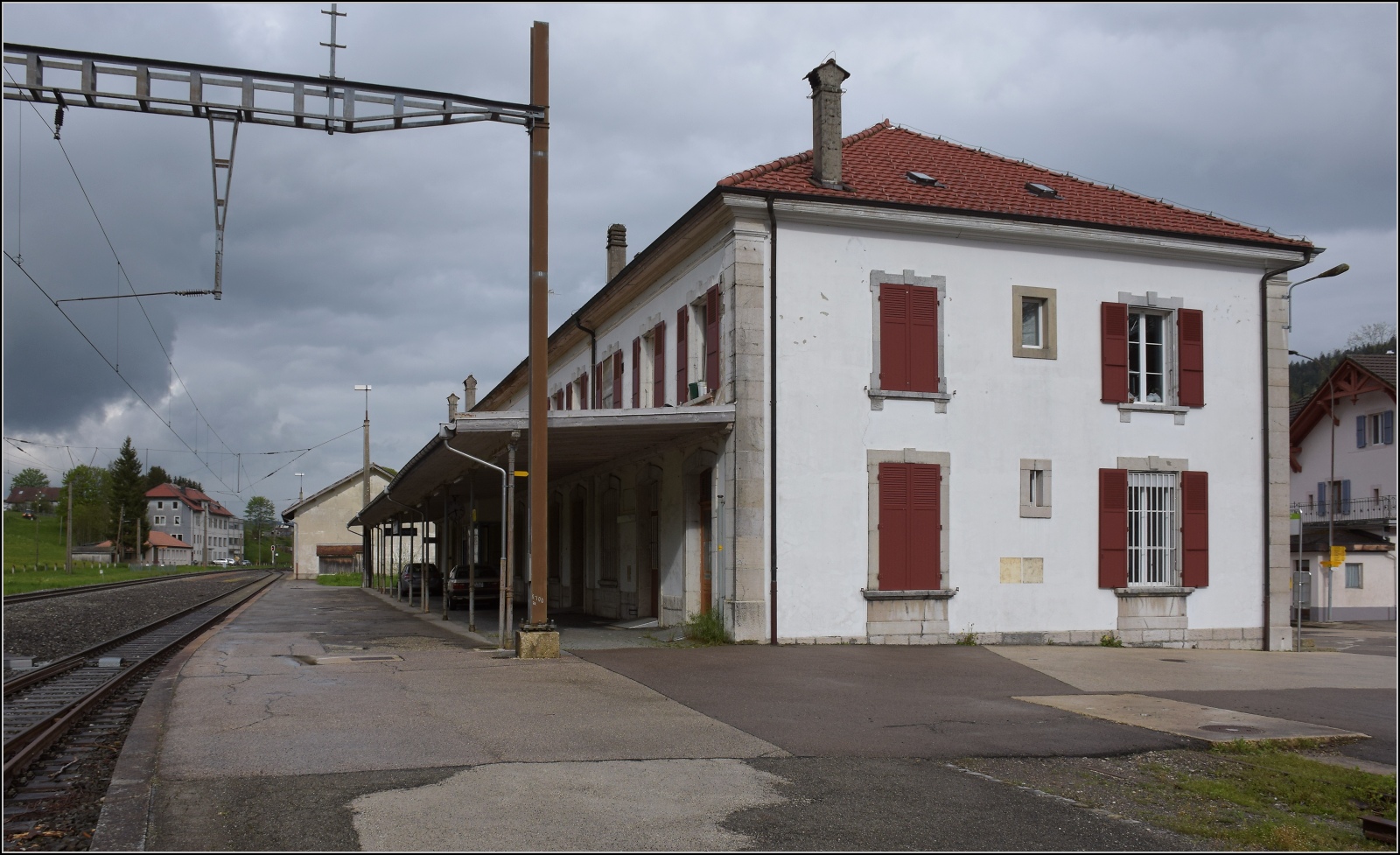 Über Les Verrières wurde die Strecke von Neuenburg nach Frankreich bereits 1860 in Betrieb genommen. Viel ist hier nicht mehr los. Alle Personenzüge fahren durch. Blick auf das stattliche Empfangsgebäude, das sich noch in passablen Zustand befindet. Mai 2023.