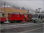 Zwischen bunten Zügen ein etwas verdeckter Blick auf den CEV Schneeräumzug mit HGe 2/2 N° 1 und Xrot 91.