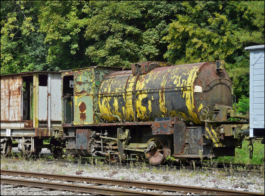 . Verborgene Schtze bei der Museumsbahn Train 1900 in Fond de Gras - Am 13.09.2009 fiel mir bei einem Rundgang ber das Gelnde der Museumsbahn diese feuerlose Lok auf und wurde bildlich festgehalten. (Hans)

Technische Daten:

Feuerlose Lokomotive No 123, zweiachsig, von ARBED Differdingen (vormals HADIR)
Erbaut im Jahre 1928 von  La Meuse  in Lttich, Fabriknummer: 3332
Leistung 285 PS, Gewicht 38 t.

Das Funktionsprinzip einer feuerlosen Dampflokomotive sieht folgendermaen aus: Der bliche Lokomotivrahmen trgt einen zylinderfrmigen Druckbehlter der etwa bis zur Hlfte mit Wasser gefllt ist. ber eine mobile Verbindung tritt ein Dampfstrahl von etwa 10 bar, der von einer stationren Dampfkesselanlage geliefert wird in den wassergefllten Bereich. Demzufolge wird das Wasser erwrmt und nach einiger Zeit (etwa einer halben Stunde) hat sich im Druckbehlter der Zustand eingestellt, der dem zugefhrten Dampf entspricht (Druck 10 bar, Wassertemperatur 200 C). Die Lokomotive wird von der Fllstation losgekuppelt und im Dampfraum oberhalb des Wasserspiegels wird Dampf entnommen, der die Lokomotive antreibt. In dem Masse wie Dampf entnommen wird, fhrt die im Wasser gespeicherte Wrmemenge zu Dampfentwicklung: Die Temperatur des Wassers sinkt und entsprechend der Druck des zur Verfgung stehenden Dampfes. Ist ein Druck von ca. 2 bar erreicht, fhrt die Lokomotive die nchstgelegene Fllstation an, und der Zyklus beginnt von Neuem.
