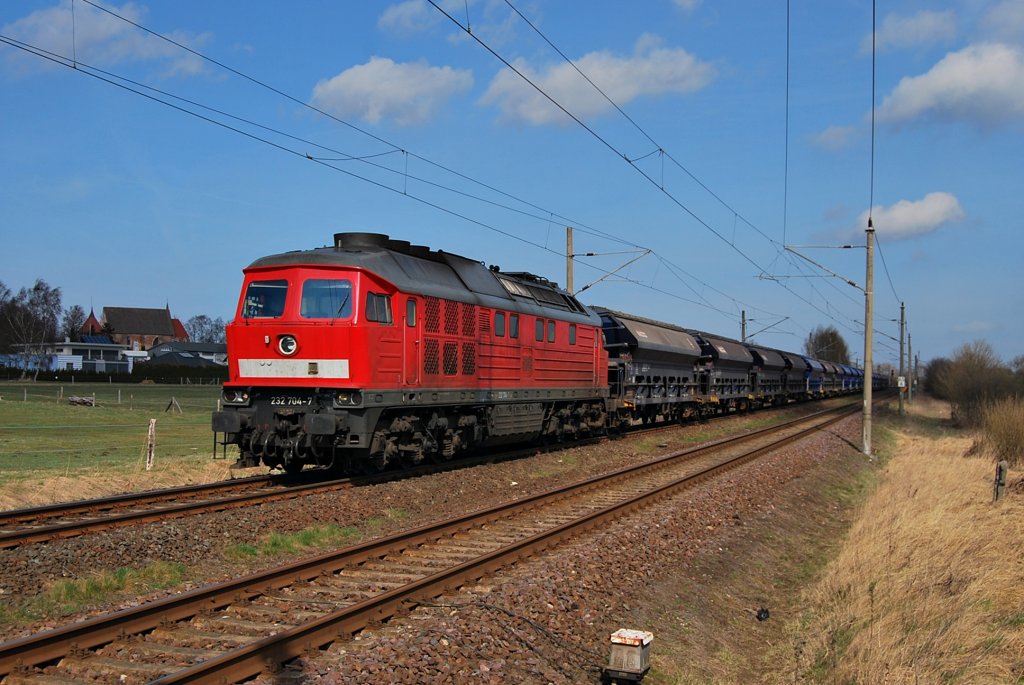 232 704 rollt mit ihrem Zug am 01.04.2011 durch Bentwisch in Richtung Rostock-Seehafen.