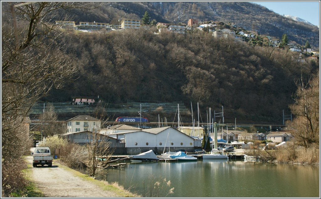 Das Bild zeigt, wie nicht ganz einfach sich die Fotogarfie der Strecke Cadenazzo - Luino gestaltet: Lrmschutzwnde, Schattenlage und relativ schlechter Zugang. Zugegebenermaen war mein Fotostandpunkt fr dieses Bild auch nicht gerade ideal. Re 474 mit einem nordwrts fahrenden Gterzug bei Magadino.
21. Mrz 2013