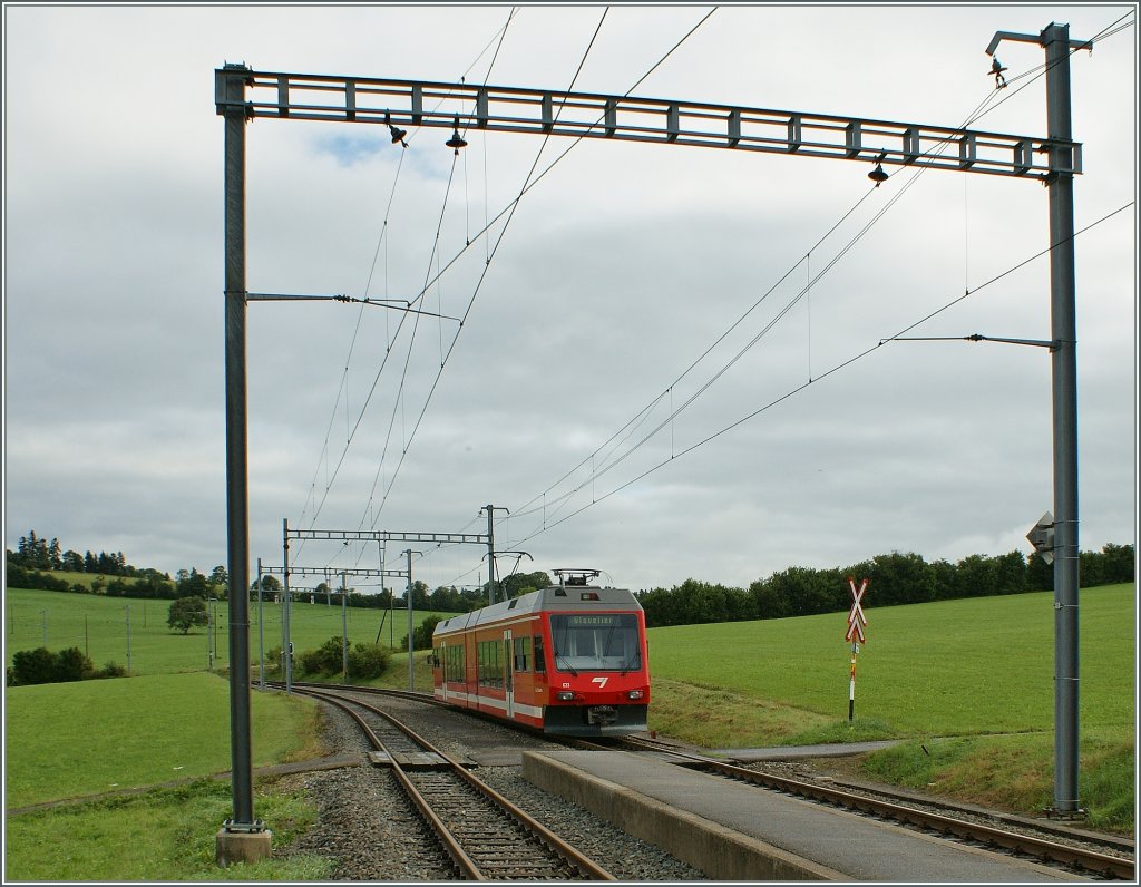 Der CJ GTW au der Fahrt nach Glovelier wird von einem Fahrleitungsmast der Station La Cibourg eingerahmt. 
19. Aug. 2010.