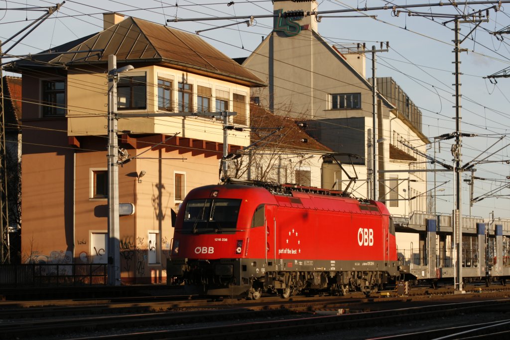 Die 1216.238 passiert das Grazer Stellwerk 2 bei der Ausfahrt in Richtung Bruck/Mur am 08.03.2013 mit einer Leergarnitur Autotransportwagen