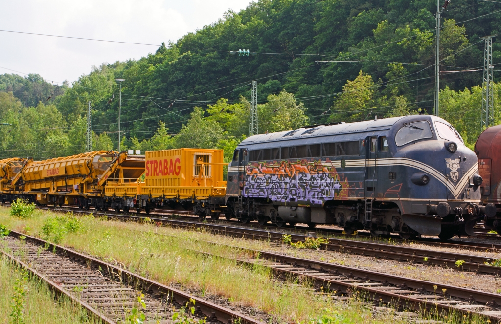 
Die 227 007-2, ex DSB MY 1147, dieser Typ ist in Deutschland auch bekannt als V 170 (eingestell als 92 80 1227 007-2 D-EIVEL) der STRABAG Rail GmbH, abgestell mit Bauzug (Materialförder- und Siloeinheit) am 30.05.2012 in Betzdorf/Sieg, leider bwaren hier Schmierfinken am Werk.  

Die Lok wurde 1964 für die DSB von Nydqvist och Holm AB (NoHAB) im schwedischen Trollhättan gebaut, ihr GM type 567C, 16 Zylinder, zweitakt-Motor hat eine Leistung von 1433 kW (1950 PS) bei 835 U/min, die Kraftübertragung erfolgt dieselelektrisch, die Höchstgeschwindigkeit 133 km/h. 

Die NOHAB AA16, auch „NOHAB“ oder umgangssprachlich „Kartoffelkäfer“ genannt, ist die europäische Lizenz-Variante der amerikanischen Standardlokomotiven der F-Reihe von EMD, seinerzeit einer Tochter des GM-Konzerns. Diese dieselelektrische Lok wurde von vielen Bahnverwaltungen in Ost- und Westeuropa in Varianten mit den Achsfolgen Co'Co' oder (A1A)(A1A) beschafft und ist noch heute im Einsatz. Benannt sind die NOHABs nach ihrem ersten europäischen Hersteller, Nydqvist och Holm AB im schwedischen Trollhättan. Dabei hat sich der Begriff „NOHAB“ für diese Loktype eingebürgert, obwohl das Unternehmen auch viele andere Loks gebaut hat, darunter etliche weitere Dieselloks mit EMD-Technik. Wer nach mehr über diese Loks wissen möchte hier drei Links: 
http://de.wikipedia.org/wiki/NoHAB_AA16 
http://www.sebtus.de/hist_v_170_story.html
http://nohab-gm.de/index.php