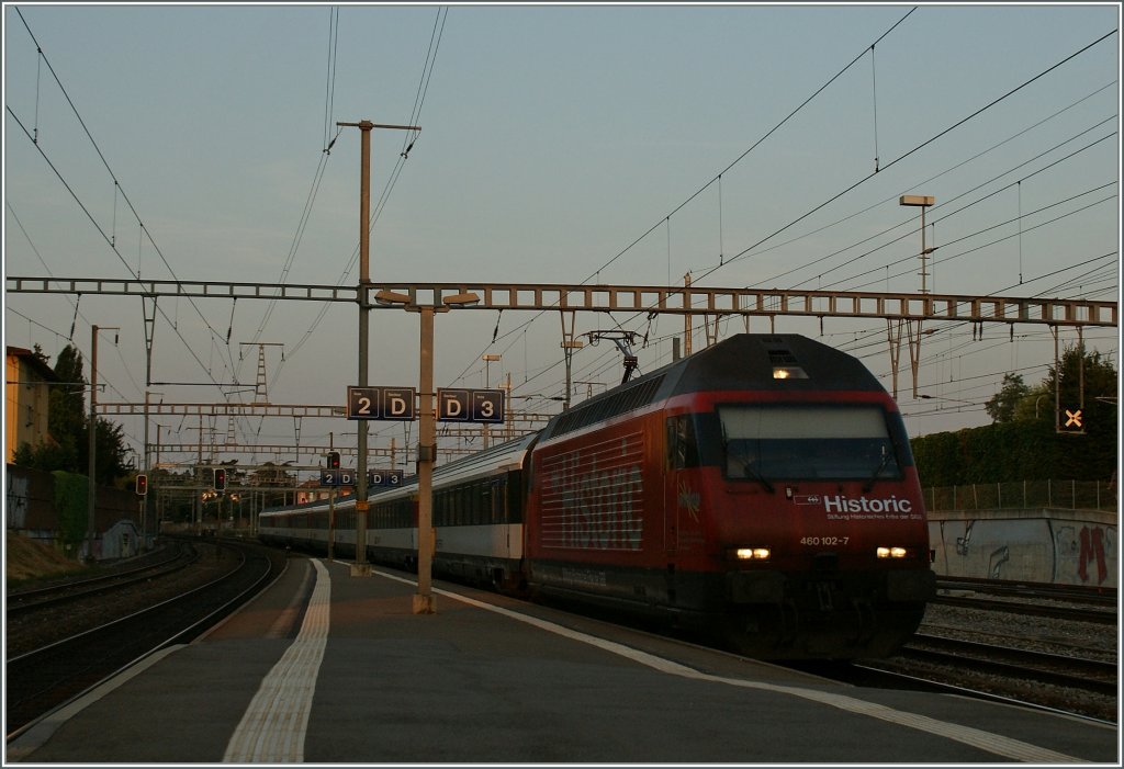 Die ersten Sonnenstrahlen und die SBB Re 460 112-7 mit ihrem IR 2515 erreichen den Bahnhof Morges.
23. Juli 2013