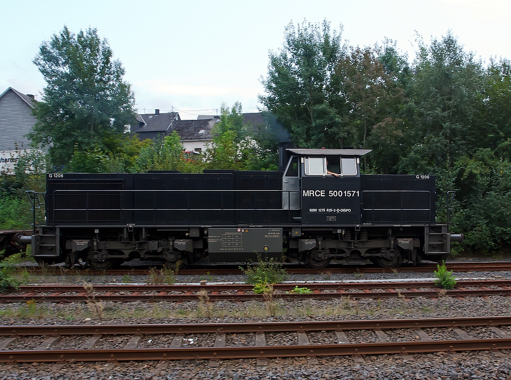 Die MRCE 500 1517 (275 625-2), eine Vossloh G 1206, mit leeren Sammnps Flachwagen (6-achsig) Ganzzug, fhrt, am 23.08.2011, von Herdorf weiter Richtung Betzdorf. Die Lok wurde 2006 von Vossloh unter Fabriknummer 5001571 gebaut. 