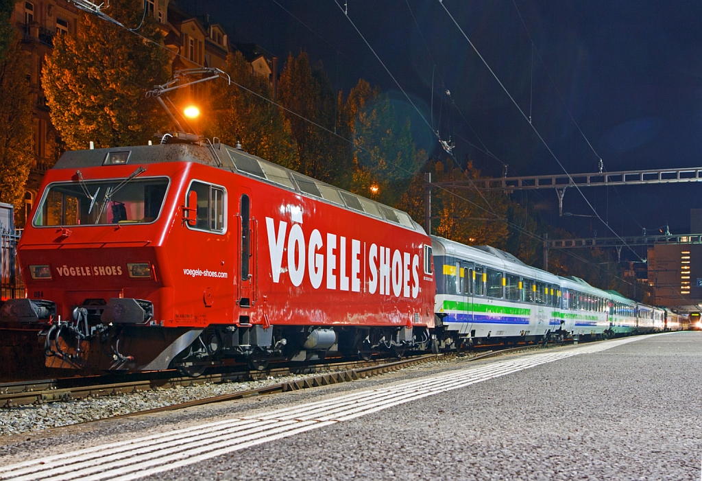 
Die SOB (Südostbahn) Re 456 094-2 (91 85 4456 094-2 CH- SOB)  Herisau  im Vögele Shoes Design ist am 29.09.2012 (3:30 Uhr) mit dem Voralpen Express in Luzern abgestellt. 

Diese vierachsige (Bo' Bo') normalspurige Lokomotive in Umrichtertechnik wurde 1987/88 von SLM und BBC für die Bodensee-Toggenburg-Bahn (BT) gebaut, die 2001 mit der SOB fusionierte. Die Lok hat eine Dauerleistung von 3200 kW, die Höchstgeschwindigkeit beträgt 130 km/h, sie hat ein Gewicht  von 68.0 t und eine Länge über Puffer von 16.60 m .