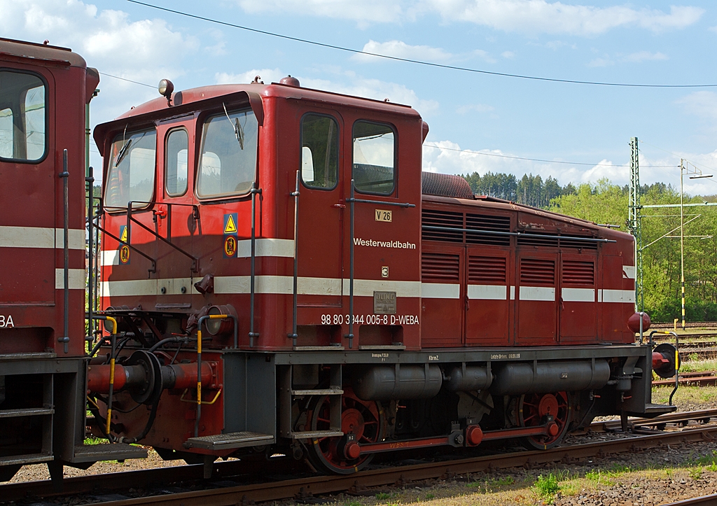 Die Westerwaldbahn (WEBA) Lok 3 (V 26.3) am 06.05.2013 in Scheuerfeld/Sieg. 

Die Jung Lok vom Typ R 30 B wurden bei der Firma Jung in Kirchen/Sieg 1957 unter der Fabriknummer 12748 gebaut und als V 26.3 an die WEBA geliefert. 
Hier in Doppeltraktion abgestellt (links die V 26.1), in dieser Einsatzform werden sie Fhrerhaus an Fhrerhaus gekuppelt, an den Fhrerhausrckwnden sind bergangsmglichkeiten zur jeweils anderen Maschine.
Die WEBA hatte 4 dieser Jung R 30 B Loks, diese zwei Loks sind heute noch als Reserveloks erhalten geblieben. 
Sie hat die NVR-Nummer 98 80 3944 005-8 D-WEBA.
Die Maschinen besitzen ein hydraulisches Getriebe (diesel-hydraulische Lok),  die Kraftbertragung erfolgt vom Getriebe mittels Blindwellen ber Treibstangen auf die Rder. 

Technische Daten: 
Achsformel: B
Lnge ber Puffer:  7.680 mm
Achsabstand: 3.000 mm
Gewicht der Lok: 28 t
Hchstgeschwindigkeit: 46 km/h (23,4 km/h im Rangiergang)
Leistung: 191 kW (260 PS)