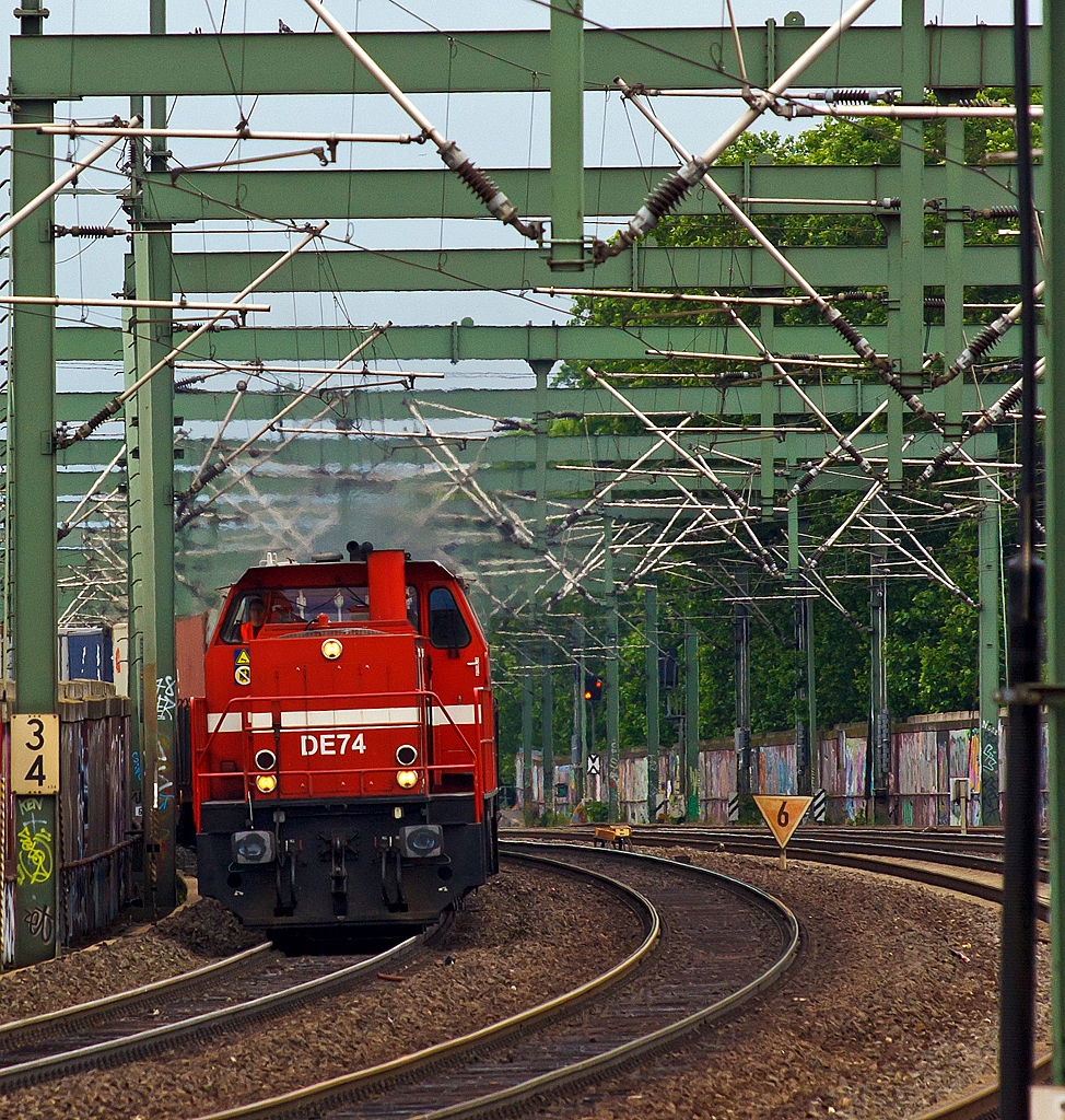 Durch den Gleisbogen kommt die DE 74 (272 012-2) der HGK (Hfen und Gterverkehr Kln AG) ex KBE DE 84 und zieht am 03.07.2013 beim Bahnhof Kln-Ehrenfeld einen Containerzug in Richtung Aachen.

Sie ist eine dieselelektrische Lokomotive vom Typ MaK DE 1002 und wurde 1986 bei MaK unter der Fabriknummer 1000836 gebaut und an die KBE (Kln-Bonner Eisenbahn), 1992, bei der Verschmelzung zur HGK, umbezeichnung in HGK DE 74. Sie trgt die NVR-Nummer 98 80 0272 012-2 D-HGK und EBA-Nummer EBA 01K14A 074.