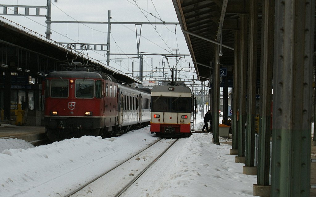 Eine Re 4/4 II mit ihrem Regionalzug nach Biel/Bienne und der TRN/cmn Be 4/4 nach Les Ponts de Marteles warten auf die Abfahrt in La Chaux de Fonds.
16. Feb. 2010