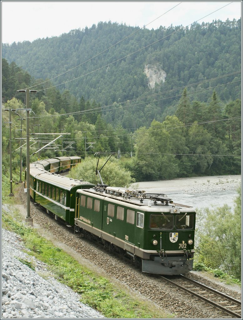 Frher, als die RhB wie die meisten Bahnen grn lackiert waren, fielen die Zge in der prchtigen Landschaft kaum auf. Heute kann man sich das kaum mehr vorstellen, aber mit ein paar Handgriffen die Erinnerung an lngst vergangene Zeiten wecken... Ge 6/6 II 702 mit dem RE 1253 am 13. August 2010 kurz vor Versam Safien auf der Fahrt von Disentis nach Scuol-Tarasp.
