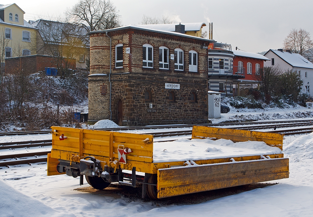 Gegenber dem 1901 gebautem Stellwerk Herdorf Fahrdienstleiter (Hf) ist am 17.01.2013 dieser Gleiskraftwagenanhnger Kla 01 (Kleinwagen-Nr. 01 0769-5) der Fa. A. Mhlbauer Bau aus Mnchen abgestellt (neben dem Gleis). 
Der Wagen ist Baujahr 1961, hat ein Eigengewicht von 3,0 t und eine Nutzlast von 5,0 t, die Gesamtlnge betrgt 2.500 mm.