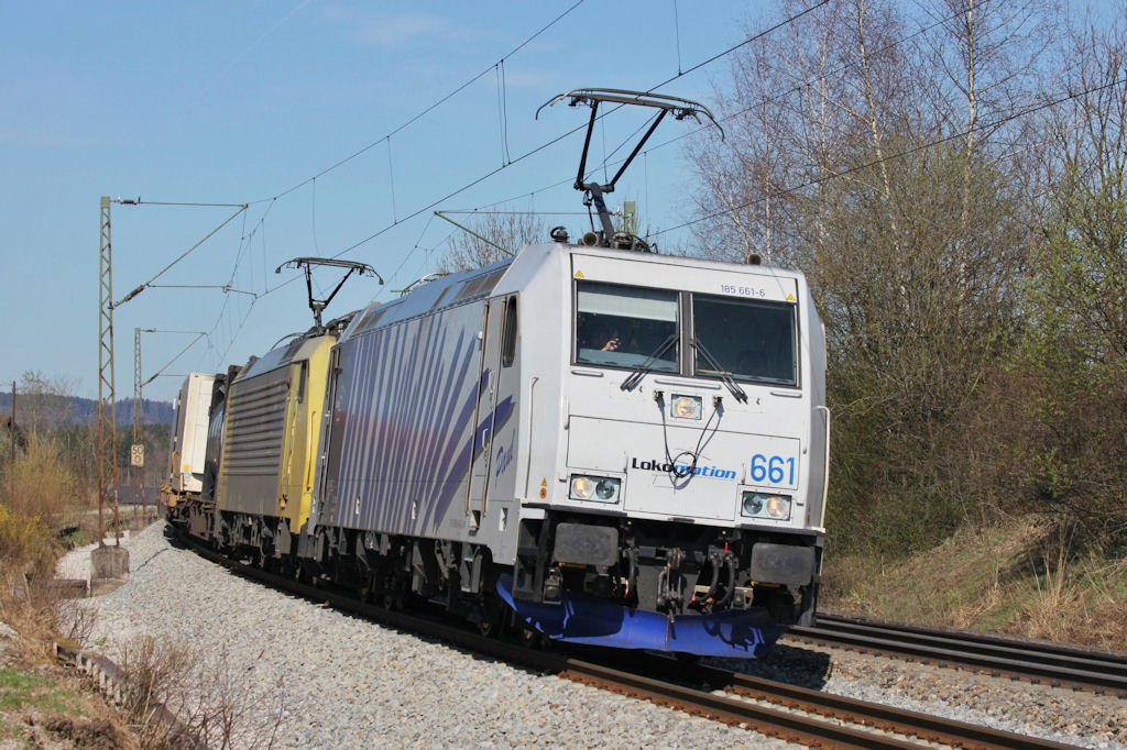 Lokomotion 185-661 mit freundlich grendem Lokfhrer bei Ostermnchen (Mnchen - Rosenheim) am 2.4.2011.