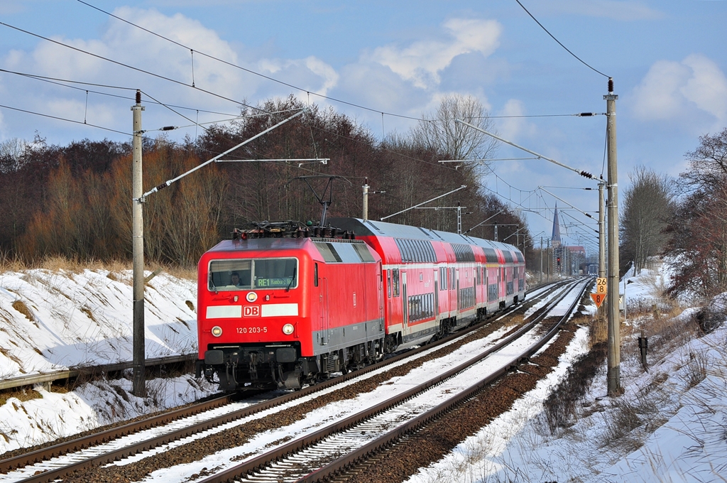 Mchtige Wolken trmen sich am 22.03.2013 ber der 120 203 auf.Kurz nachdem sie mit dem RE 4306 (Rostock-Schwerin-Hamburg) durch Sildemow sauste begann es auch wieder zu schneien..nix neues im Mrz 2013 in Rostock.