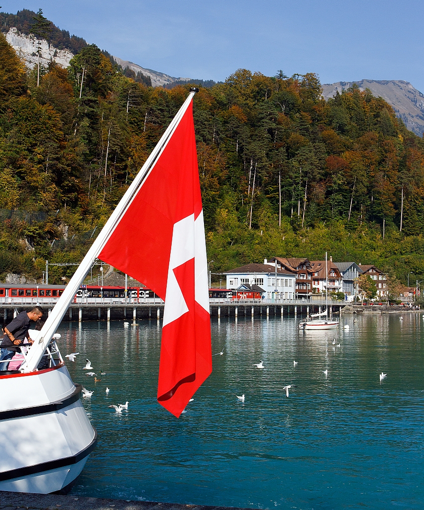 Mein Blick vom Schiffsanleger Brienz, am Heck der MS Brienz vorbei ber den Brienzersee zum Bahnhof, dort ist eine De 110 der Zentralbahn mit einem IR (Interlaken - Luzern) eingefahren (30.9.2011).