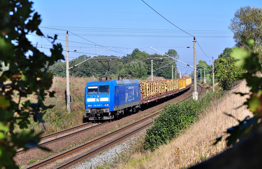 Mit einem Holzzug nach Stendal rollt die 145 030 der Press  am 12.10.2012 durch Sildemow in Richtung Schwerin.