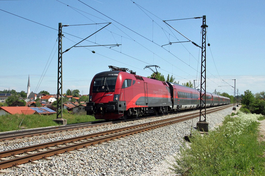 BB 1116-229 mit Railjet vor der Kulisse von Ostermnchen zwischen Rosenheim und Mnchen am 14.5.2011.